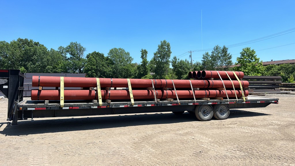 Industrial pipe bundle strapped on Red Shark Transport flatbed trailer